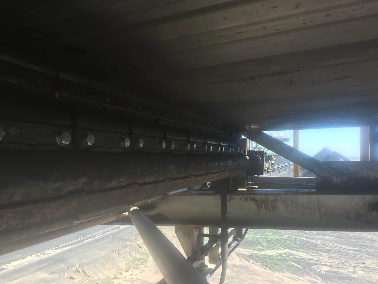 Reversible secondary cleaner installed beneath the belt, with the tip row and pole visible.