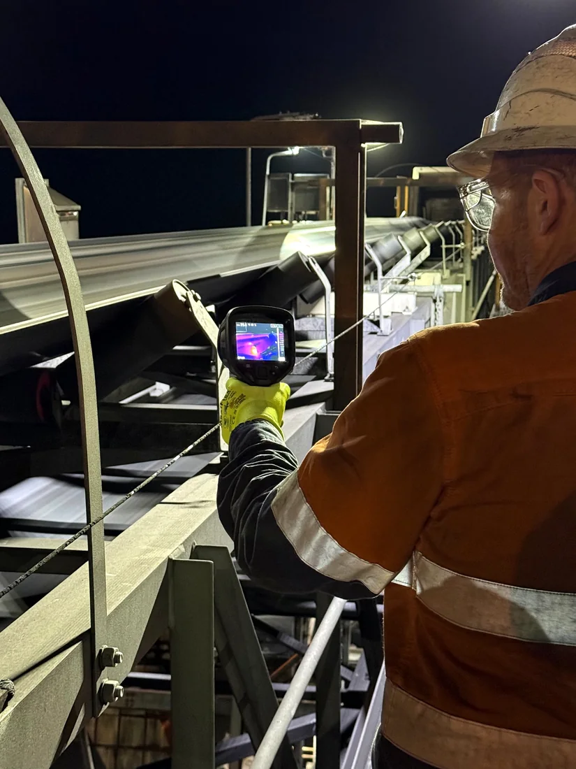 Technician carrying out a thermography inspection on a conveyor